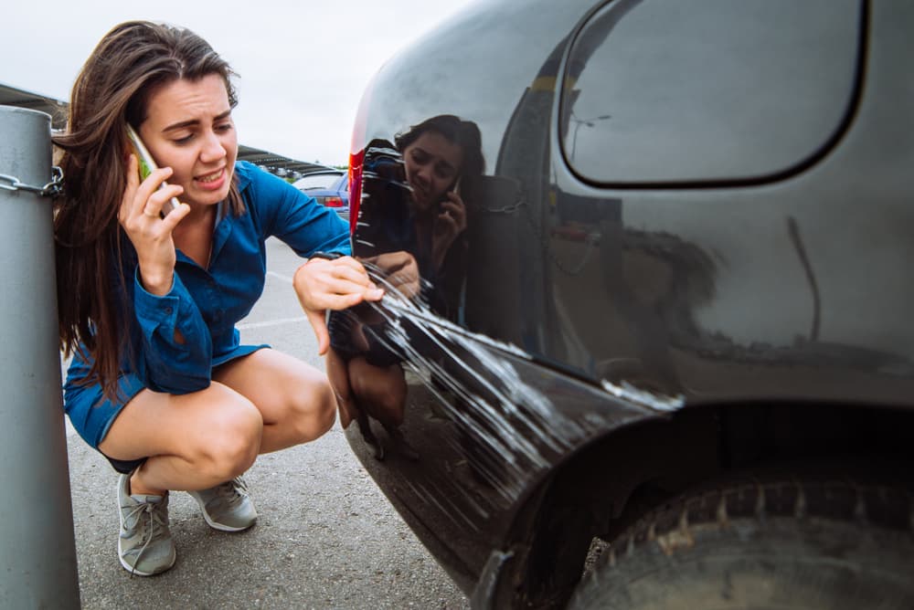 Woman on the phone after her car was scratched after an accident