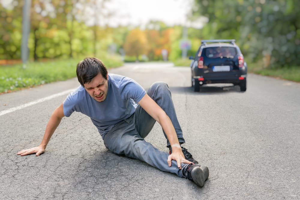 Man lying on the ground after being in a hit and run car accident