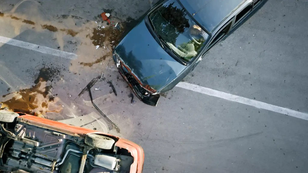 Overhead view of a car crash with debris on the road.
